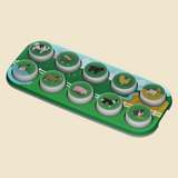 A green farm-themed circular toy or game board with ten animal illustrations, photographed on a plain beige background.