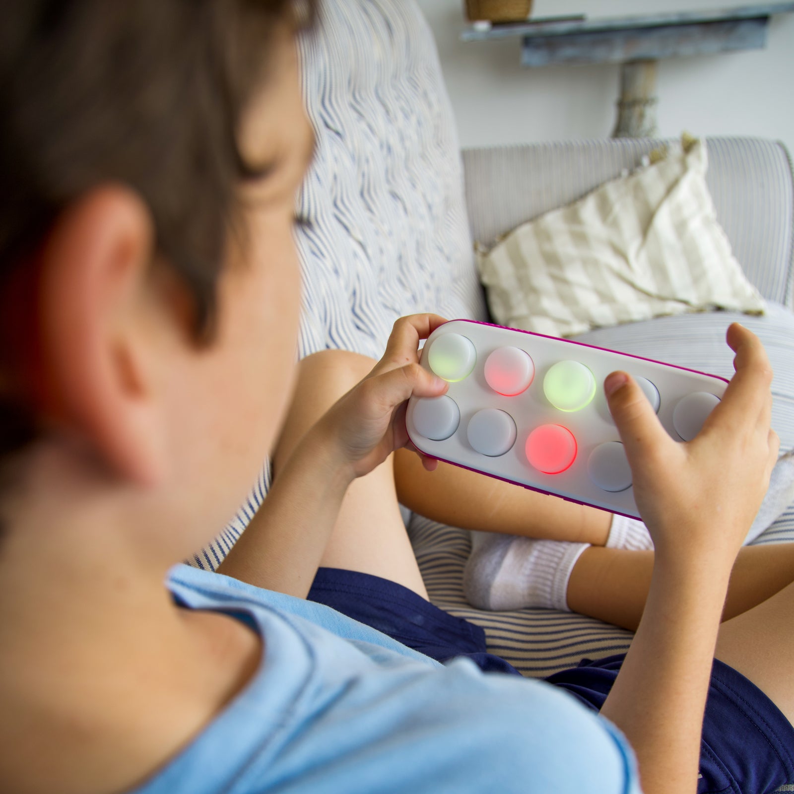 Child playing with a light-up toy on a couch