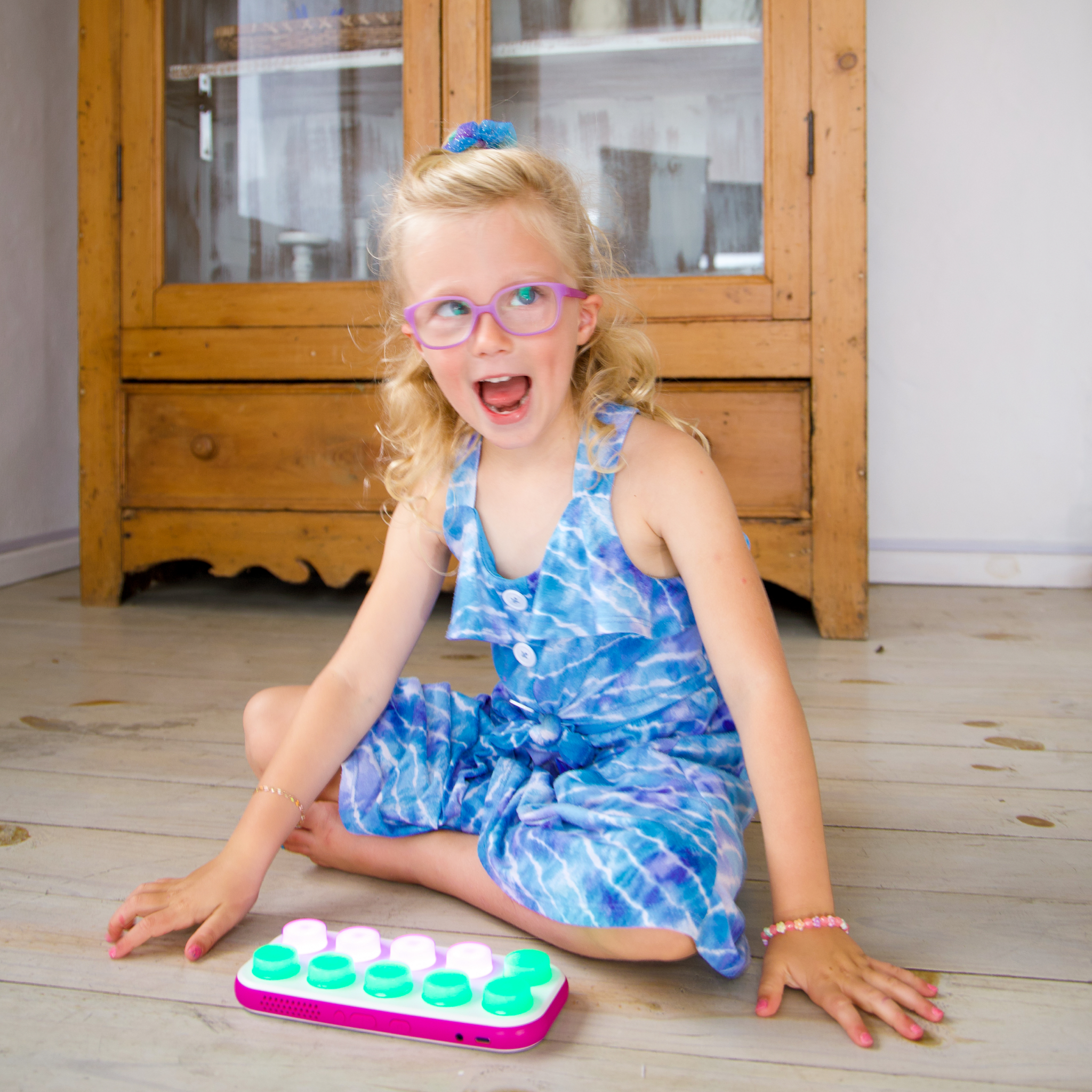 Blonde child playing a game on Boppo and smiling