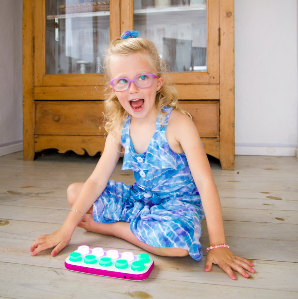 Young girl playing with a colorful toy on a wooden floor
