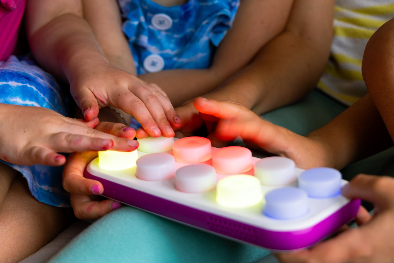 Children playing with a colorful light-up toy