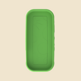 A green rectangular silicone mold or tray with rounded corners and embossed circular patterns, shown from a top-down view on a light beige background.