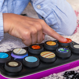 Child's hand interacting with a toy set resembling planets, A toppo on a Boppo tablet